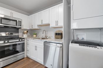 a kitchen with white cabinets and stainless steel appliances at Falls Village Apartments, Baltimore MD